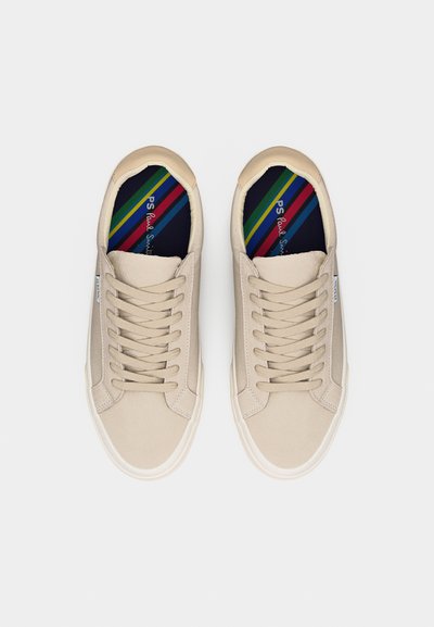 Μπεζ αθλητικά παπούτσια με κορδόνια και λευκές σόλες, με μαύρες εσωτερικές σόλες που έχουν πολύχρωμες διαγώνιες ρίγες και το λογότυπο "PS Paul Smith".