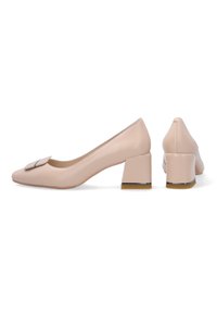 Nude kožené lodičky na bloku s čtveratou špičkou a dekorativní mašlí na přední straně. Podpatky mají kovový akcent.