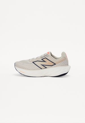Zapatilla de running gris claro con parte superior de malla, acentos en navy oscuro y una entresuela blanca acolchada. Presenta un prominente logo de "N" y un diseño texturizado.