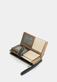 Portafoglio in pelle marrone e beige con chiusura a zip, tasche per carte, due finestre per ID trasparenti e un cinturino da polso. Presenta cuciture e accenti a contrasto.