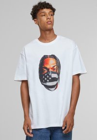 White cotton t-shirt featuring a graphic of a person with braids wearing a black and white striped mask with stars. Casual fit and short sleeves.
