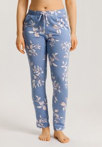Pantalones de pijama azules con flores que presentan una cintura con cordón, tela suave y un patrón de hojas blancas y rosas sobre un fondo azul.