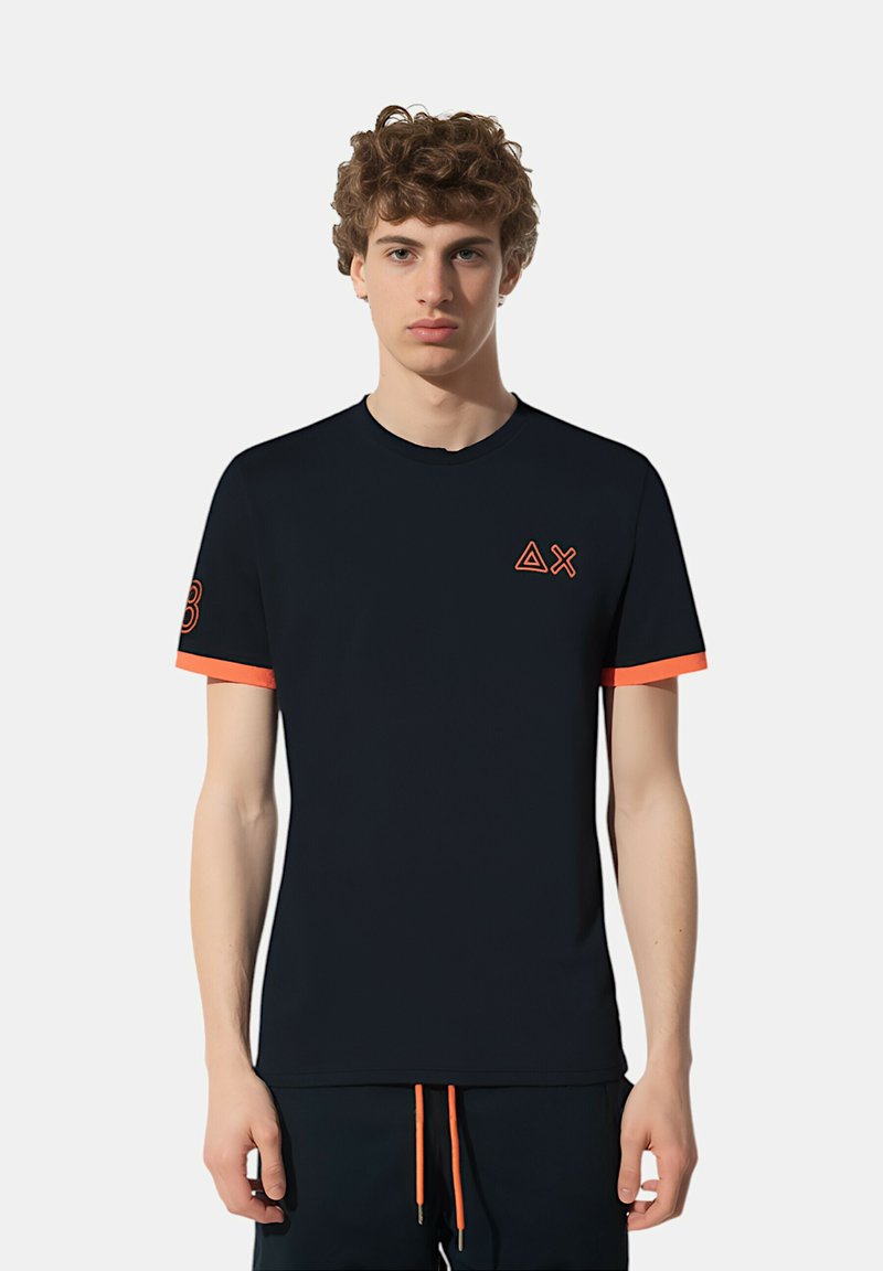 T-shirt nera a maniche corte con accenti arancioni sulle maniche e sul logo. Realizzata in tessuto morbido con scollatura a girocollo.