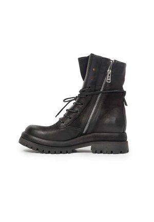 Botte de combat en cuir noir avec lacets à l'avant, fermeture éclair latérale partiellement ouverte, semelle épaisse rainurée et lacet enroulé autour de la cheville.