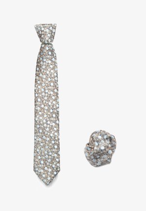 Gemusterte Krawatte und passendes Taschentuch mit hellblauen Punkten auf einem strukturierten braunen Hintergrund. Die Krawatte ist lang und schmal; das Taschentuch ist gefaltet.