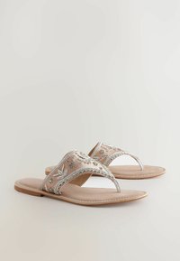 Sandali slip-on ricamati in rosa chiaro con dettagli argentati. Presentano una ampia fascia decorata e una soletta piatta per un look casual.