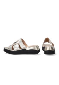 Metalen zilveren slip-on sandalen met zwarte rubberen zolen, voorzien van twee brede banden en een glanzende gouden accent op de hak.