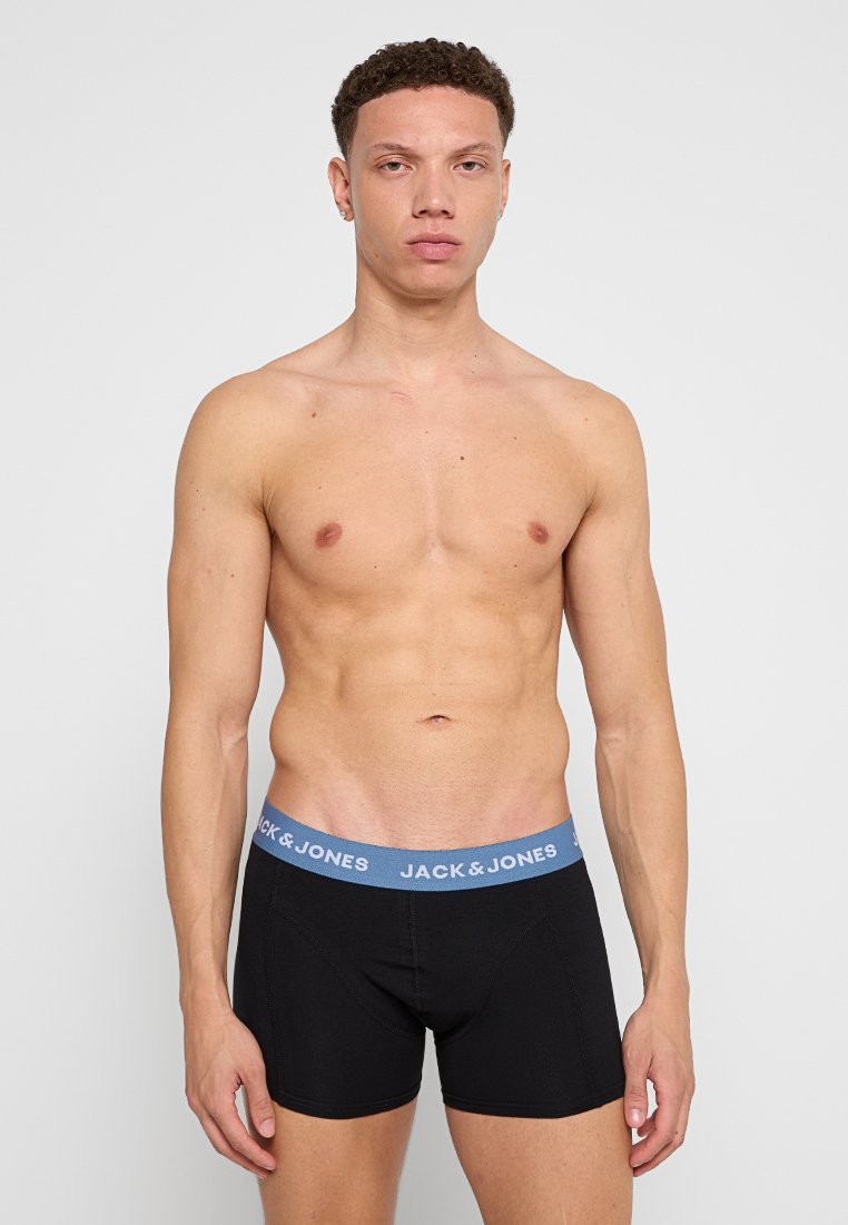 Boxer shorts negros con una cinturilla azul etiquetada "JACK & JONES". La tela parece suave, con un ajuste ceñido y costuras mínimas.