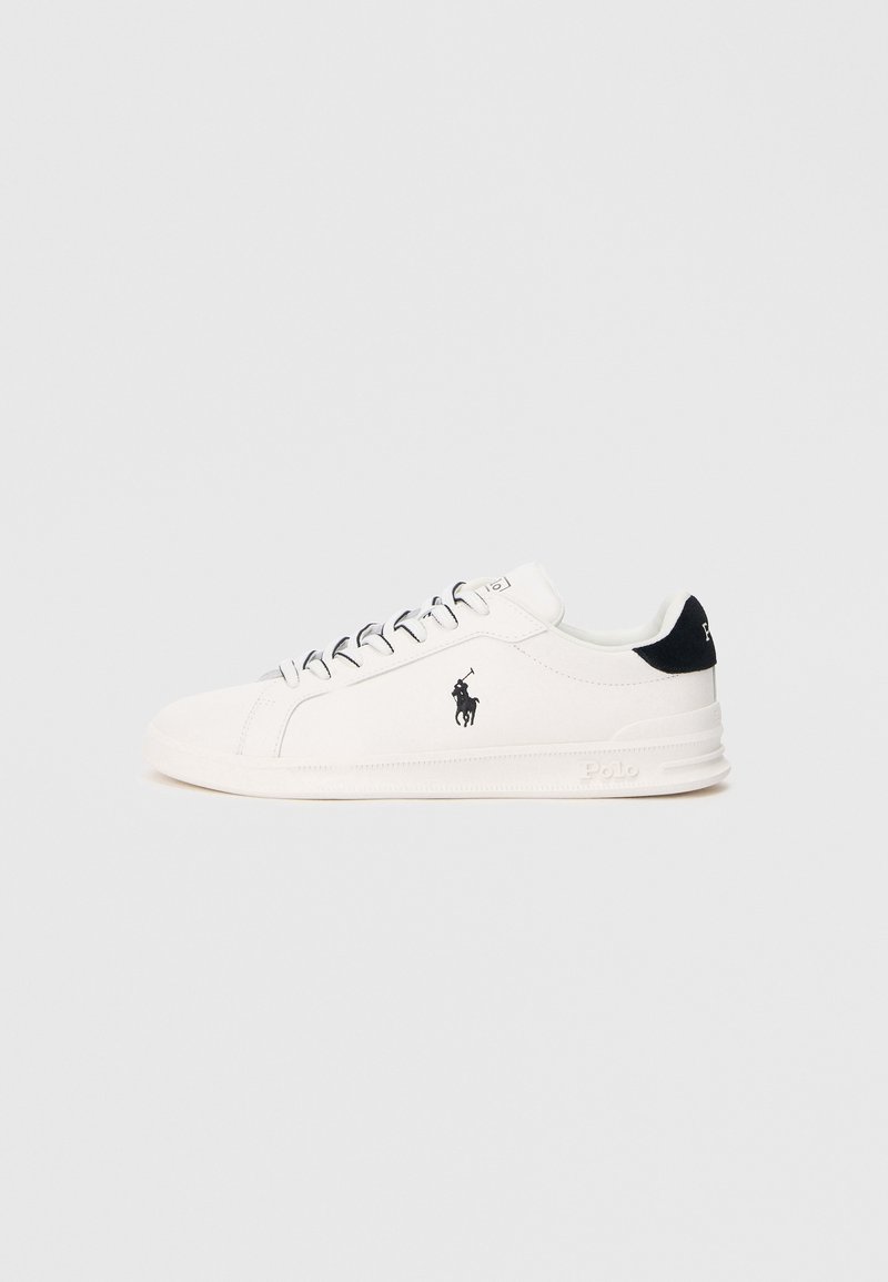 Ténis brancos com textura lisa, apresentando um logótipo preto em destaque e atacadores cinzentos. A sola é ligeiramente elevada, proporcionando um perfil elegante.