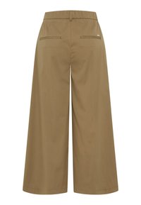 Pantalons évasés marron avec une taille élastique, deux poches arrière et une texture lisse. Caractérisés par un petit accent en métal de la marque.