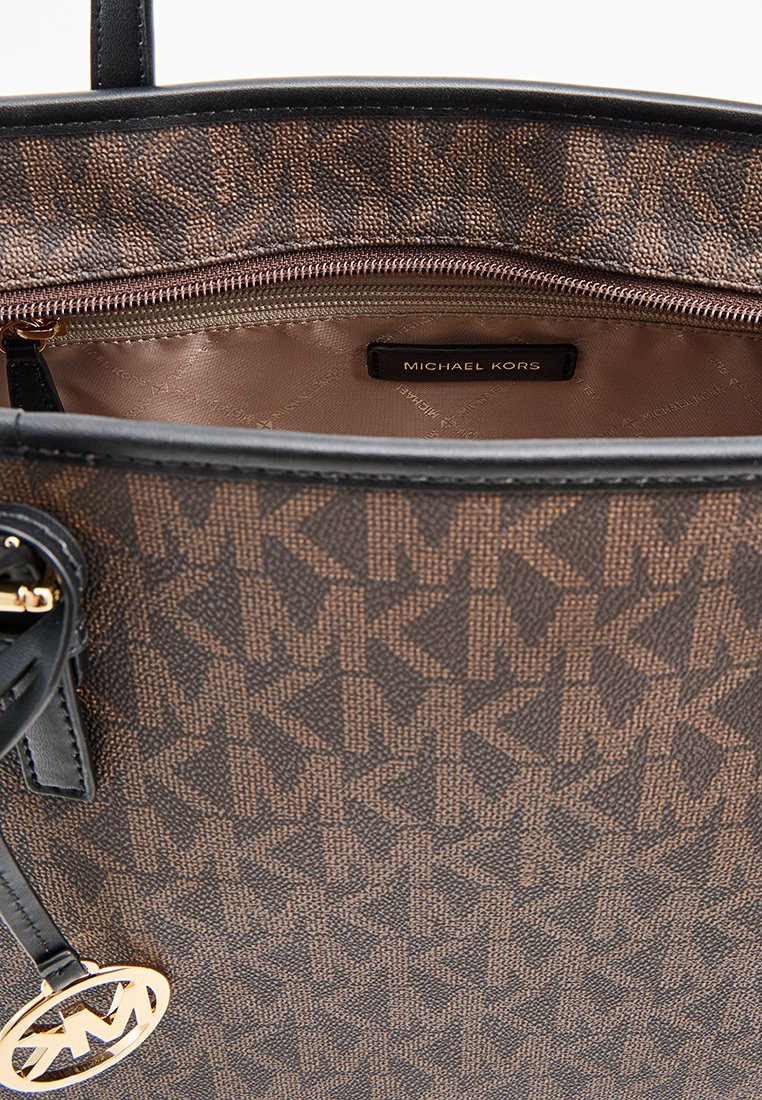 Borsa a spalla Michael Kors con un motivo monogramma marrone, dettagli neri, chiusura a cerniera e un charm con logo attaccato al manico.