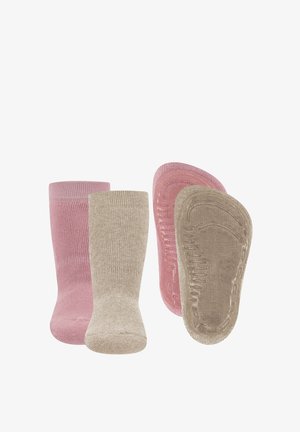 Zwei Paar rutschfeste Babysocken, ein pinkes und ein beiges Paar, Vorder- und Sohlenansicht auf weißem Hintergrund.