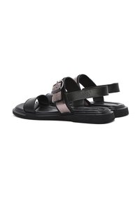 Sandali neri e metallici con fibbia, caratterizzati da un design open-toe, cinturini regolabili e una suola piatta in gomma texturizzata.