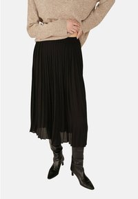 Jupe plissée noire au design fluide, fabriquée en matériau léger, avec une coupe mi-longue et une taille élastique.