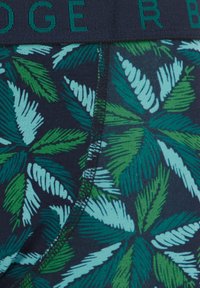 Moške bokserice s temno modro podlago, ki vključujejo teksturiran vzorec zelenih in svetlo modrih tropskih listov. Vključeno je elastično pasovanje.