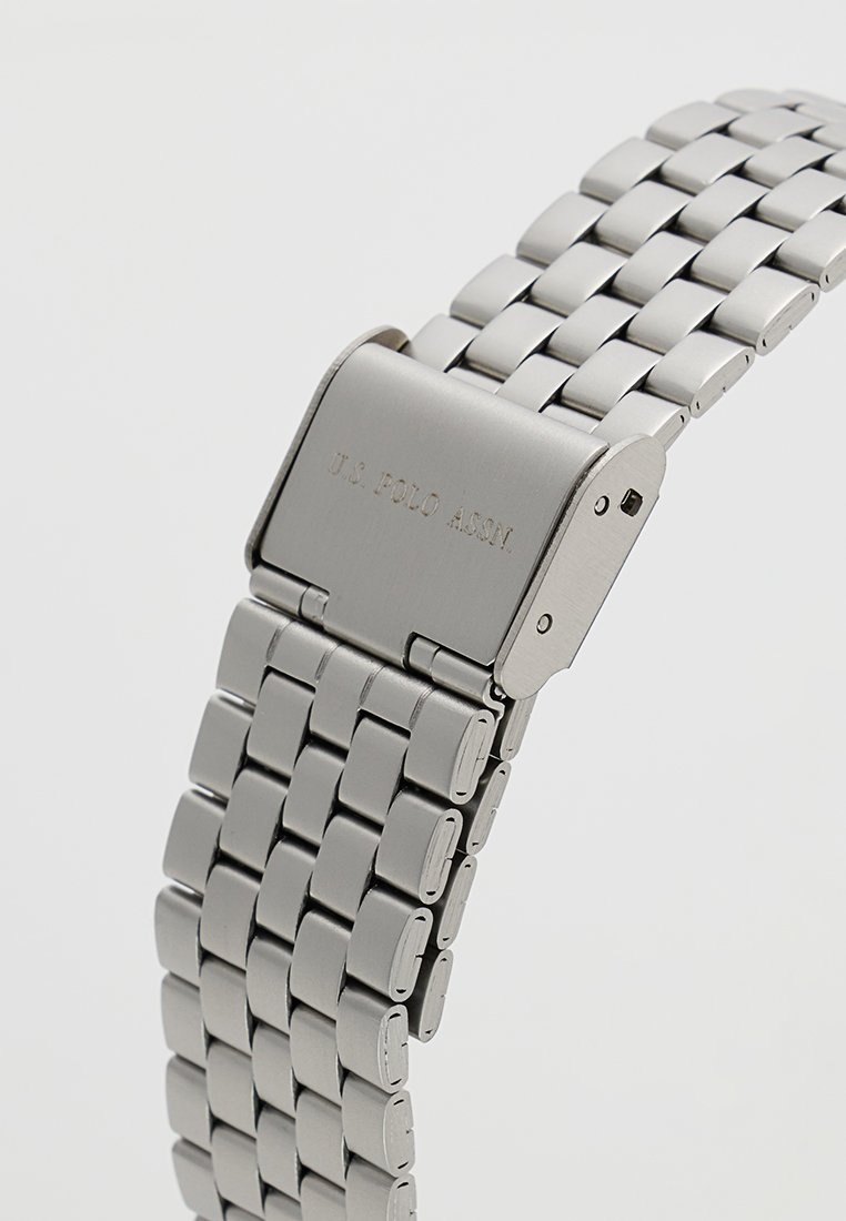 Orologio da polso in metallo con bracciale in acciaio inossidabile argentato, cassa rettangolare e logo inciso sulla chiusura.