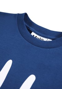 T-shirt de algodão azul-marinho com decote redondo, apresentando um grande design gráfico branco na frente e uma etiqueta dentro do colarinho.
