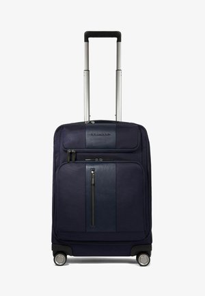 Maleta rodante de color azul oscuro con un exterior de tela texturizada, panel de cuero horizontal, dobles cremalleras y dos ruedas giratorias suaves.