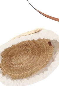 Geflochtene Strohtasche mit runder Form, cremefarbener Stoffauskleidung, gerafftem Rand und einem braunen Ledergriff. Das Innere hat eine natürliche geflochtene Textur.