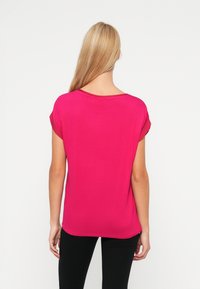 Kortärmad, fuchsiasfärgad T-shirt med rundad halsringning och avslappnad passform, tillverkad av mjukt tyg med en slät yta.