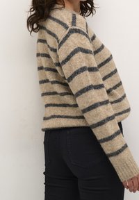 Beżowy sweter z ciemnoniebieskimi poziomymi paskami, wykonany z teksturowanej dzianiny. Posiada długie rękawy i okrągły dekolt.