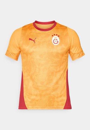Oranje en rode sporttrui met een textuurpatroon, korte mouwen, ronde hals en Puma-logo. Heeft een circulair embleem met sterren.