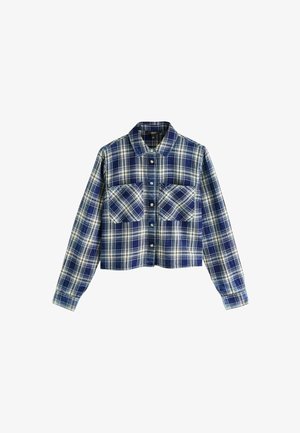 Lühendatud ruudulise mustriga särk sinise, valge ja tumesinise värviga. Omab nööbitavat esiosa, kahte rinnaüht ja traditsioonilist kraed. Puuvillane kangas.