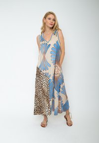 Ärmelloses Kleid mit einem hellbeigen Hintergrund und blauen Blumenmustern sowie einem Leopardenprint-Bereich. Lockere Passform, leichtes Material.
