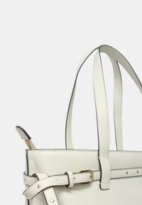 Borsa a tracolla in pelle bianca con forma strutturata, caratterizzata da una texture liscia, bordi neri in contrasto, tracolla regolabile e accessori in tonalità oro.