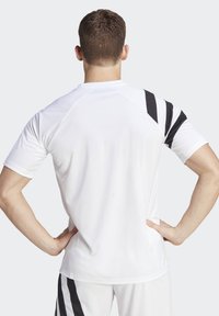 Hvid sporty atletisk skjorte til mænd med sorte diagonale striber på den højre skulder. Fremstillet af letvægtigt, fugtabsorberende materiale.