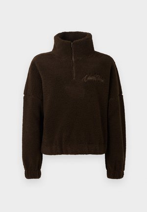 Brun fleecepullover med høj krave, halv lynlås fortil og ribbestrikkede manchetter. Indeholder broderet tekst på brystet. Blød tekstur.