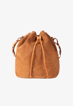Tan suede bucket bag with drawstring closure and adjustable shoulder strap, soft texture and minimal branding at the bottom center.