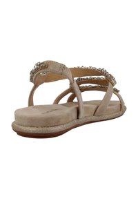 Sandalo beige con design a tre cinghie, impreziosito da piccole pietre glitterate. Materiale in morbida suede e suola testurizzata e luccicante.