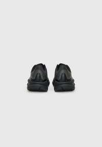 Zwarte sportieve schoenen met een gestructureerd oppervlak, uitgerust met een gewatteerde zool, een laag profiel en subtiele branding op de hiel.