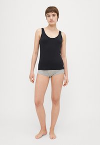 Black sleeveless top made of smooth fabric, featuring a round neckline. Paired with gray shorts, showing a plain design without patterns.