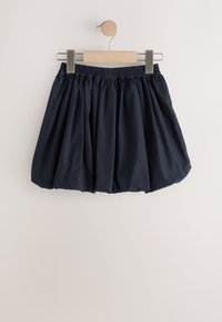 Navy blue skirt made from lightweight fabric, featuring a gathered, flared design. Elastic waistband with a wooden hanger for display.
