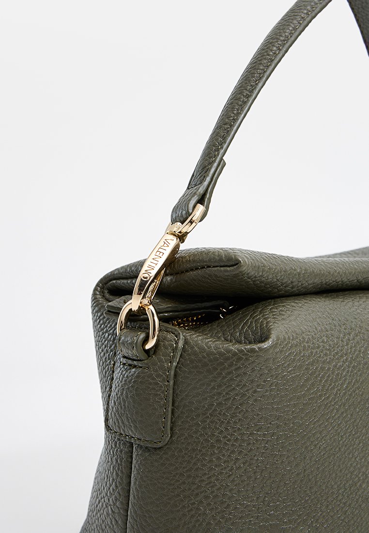 Sac à main en cuir texturé vert avec une fermeture éclair en métal doré et un accent de logo. Dispose d'une poignée supérieure et d'un corps structuré et doux.