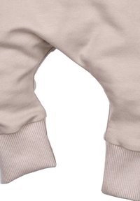 Lichtbeige stoffen jogger met geribde boorden, voorzien van een afgeronde zoom en een gladde textuur. Geschikt voor casual gebruik of ontspannen.