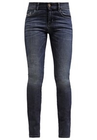 Jeans de mezclilla de corte ajustado en azul oscuro. Presenta un diseño clásico de cinco bolsillos, cierre de botón de latón y un ligero desgaste en los muslos.