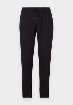 Zwarte joggingsbroek met een tailleband met trekkoord, taps toelopend ontwerp en ribgebreide boorden. Gemaakt van zachte stof, met een klein logo-detail.
