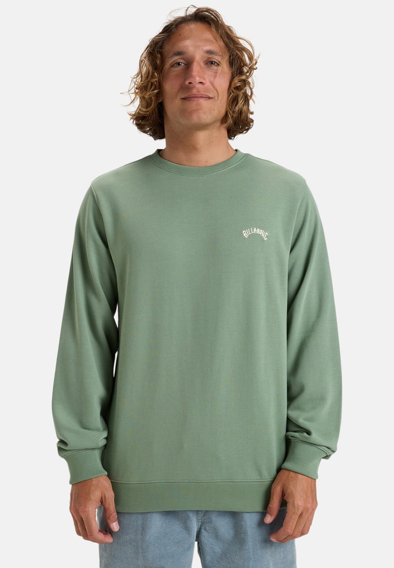 Grüner Sweatshirt mit langen Ärmeln, gerippten Bündchen und Saum, das ein kleines weißes Logo auf der Brust trägt. Aus weichem, glattem Material gefertigt.