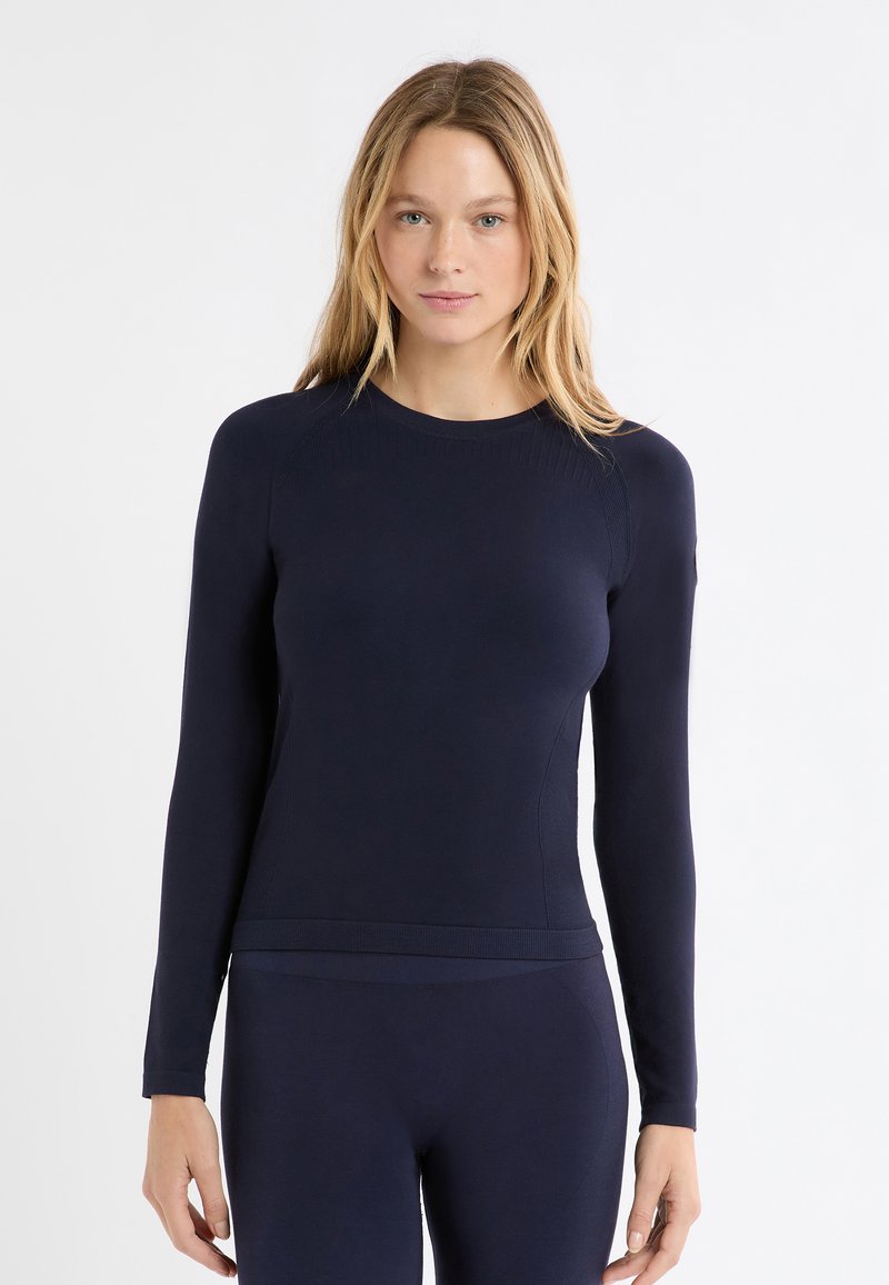 Granatowa koszulka bazowa z długim rękawem, z prążkowanymi detalami przy dekolcie i mankietach, wykonana z miękkiego, elastycznego materiału dla komfortu i dopasowania.