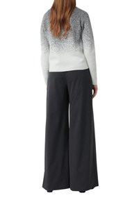 Jasnoszary sweter z fakturowanym ombre przechodzącym od ciemnego do jasnego odcienia. W komplecie szerokie spodnie o ciemnoszarym kolorze, wykonane z gładkiej tkaniny.
