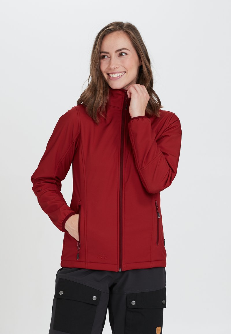 Röd softshell-jacka med hög krage, dragkedja fram och två sidofickor. Har en slät textur och en figurnära design, lämplig för utomhusbruk.