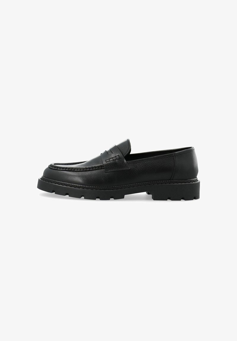 Mocassin en cuir noir avec un dessus texturé, semelle plate et semelle extérieure en caoutchouc épais. Présente des détails cousus et une large sangle sur le cou-de-pied.