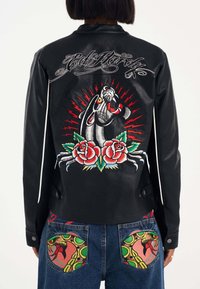 Svart läderjacka med livfulla broderade mönster av en panter och rosor på ryggen. Dekorativa detaljer och kontrasterande sömmar synliga.