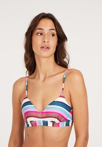 Juostinis bikinio viršus su V formos dekoltė. Pasižymi plačiomis horizontaliomis juostomis rožinės, mėlynos ir rudos spalvų. Plonos reguliuojamos petnešos, minkšta medžiaga.