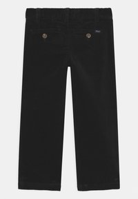 Black corduroy pants featuring a straight-leg design, textured fabric, and two back buttoned pockets. Includes a concealed elastic waistband.