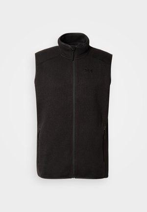 Chaleco de forro polar negro con cuello alto, cremallera frontal, dos bolsillos laterales y un detalle sutil de logo. Textura suave con una forma ajustada.