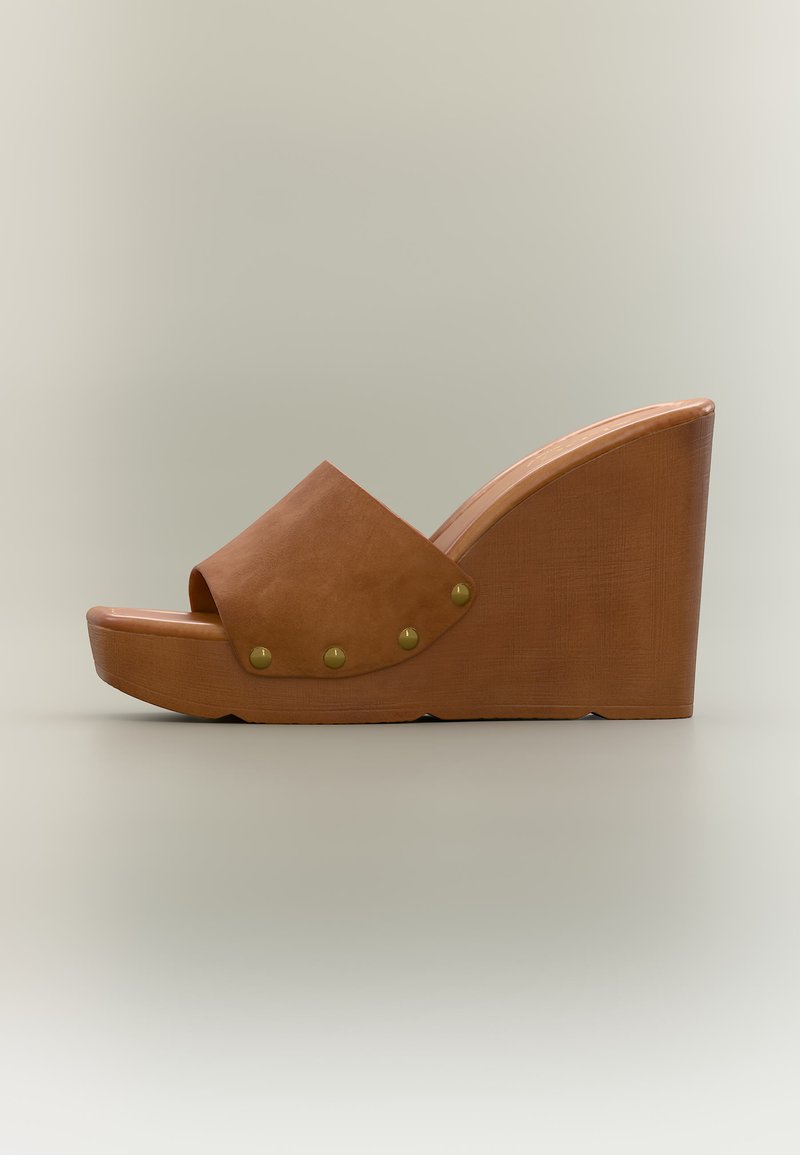 Sandale compensée en cuir marron avec bout ouvert, semelle plateforme en bois et quatre clous en laiton le long de la lanière latérale.